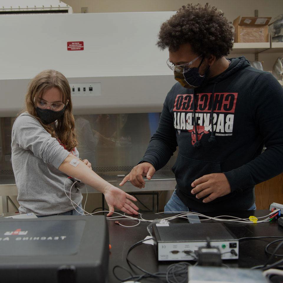 Two students test a device in their Animal Physiology class.